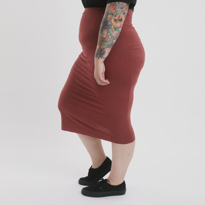 High-waisted pencil skirt from The Shapes United, made of sleek fabric, shown on a model showcasing its tailored fit.
