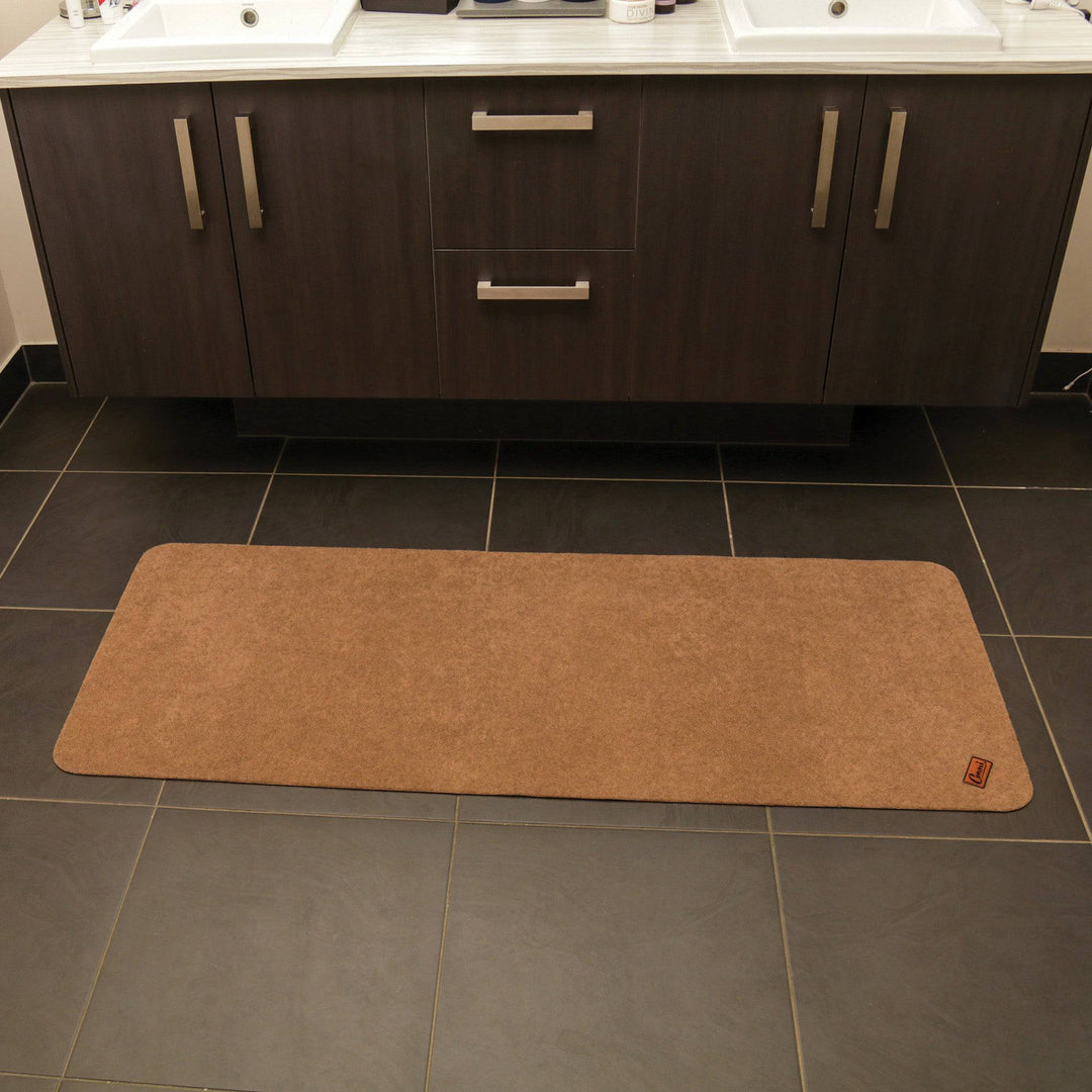 Conni Pebble long runner floor mat with anti-slip and absorbent Manchester fabric, featuring a textured pebble pattern for bathroom or kitchen.