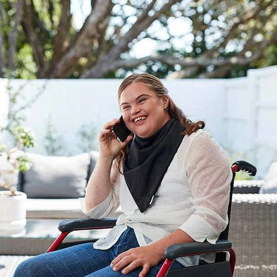 Black Brolly Bandana waterproof and absorbent adaptive clothing accessory worn by woman in wheelchair.