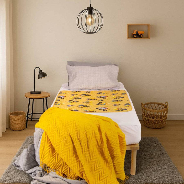 Conni Kids Bed Pad featuring a colorful truck print, designed for comfort and protection in children's bedding.
