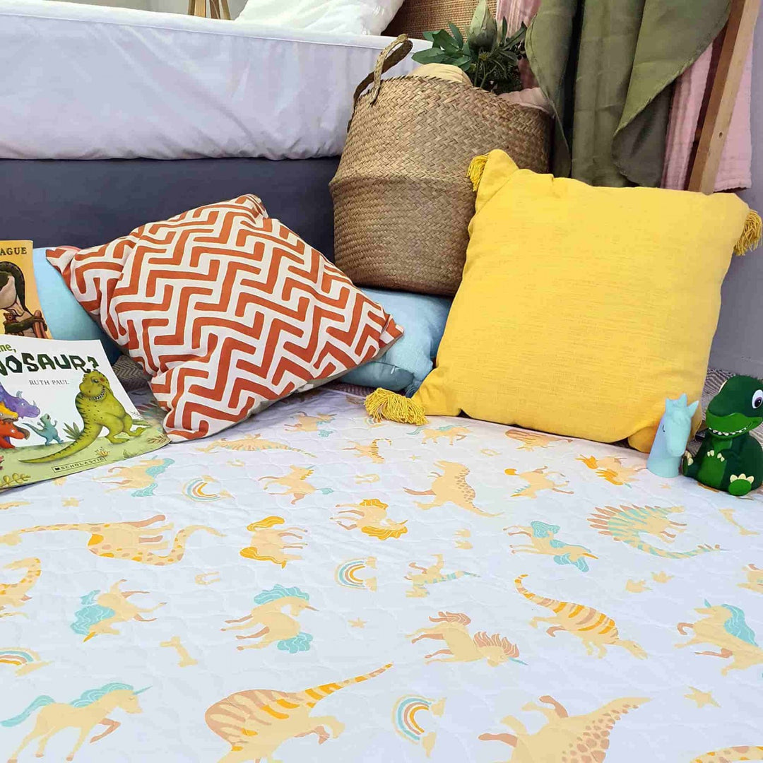 Conni Kids Bed Pad featuring a colorful unicorn and dinosaur print, perfect for children's bedding protection.