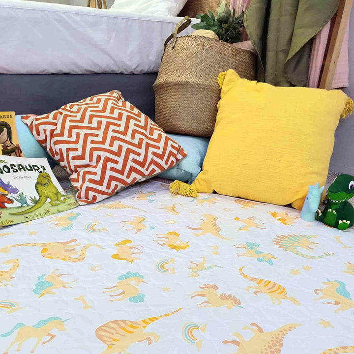 Conni Kids Bed Pad featuring a colorful unicorn and dinosaur print, perfect for children's bedding protection.