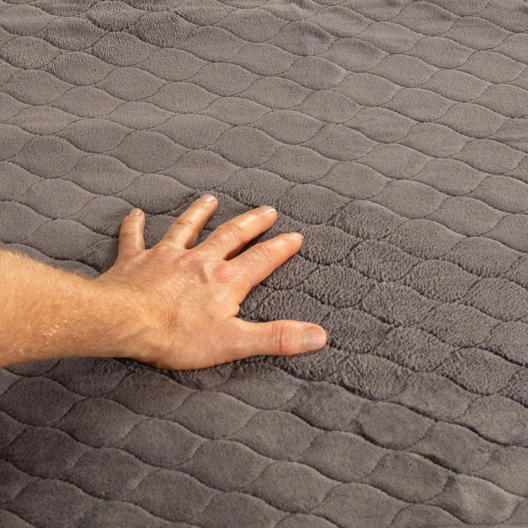 Close-up of Conni plush charcoal top bed pad with tuck-ins, made of soft Manchester fabric for added comfort.