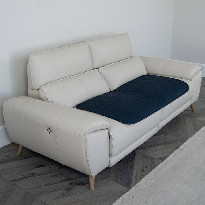 Staydry Manchester chair pad in midnight color, made by Stay Dry Products, shown on a comfortable couch.