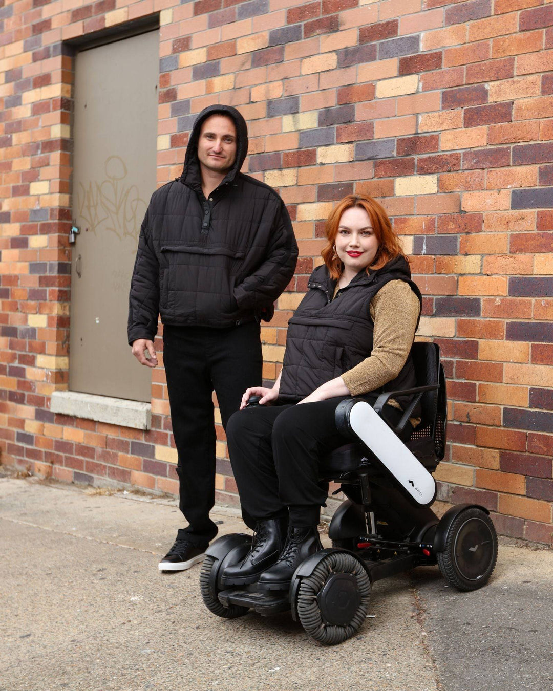 Black Elly Universal Adaptive Puffer Jacket by Christina Stephens designed for wheelchair users, showcasing its functional style.