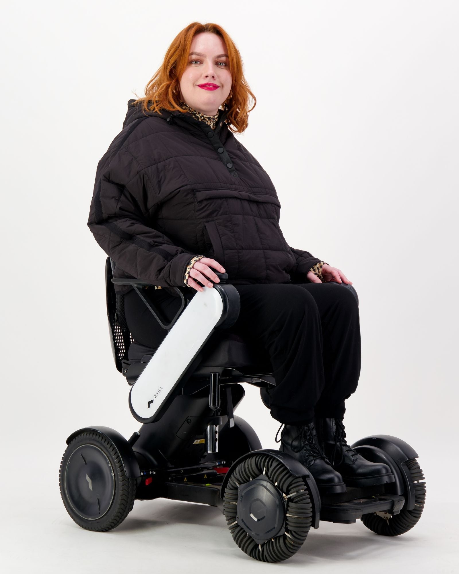 Black Elly Universal Adaptive Puffer Jacket by Christina Stephens designed for wheelchair users, showcasing its cozy, functional style.