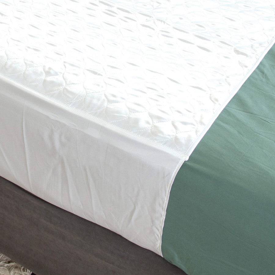 Conni Satin-Glide X-wide bed pad with tuck-ins, Manchester style, providing comfortable protection for adult beds.