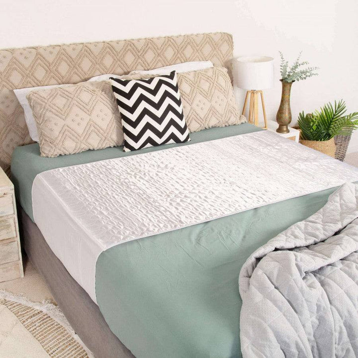 Conni Satin-Glide X-wide Manchester bed pad with tuck-ins, white, designed for secure placement and comfort during sleep.