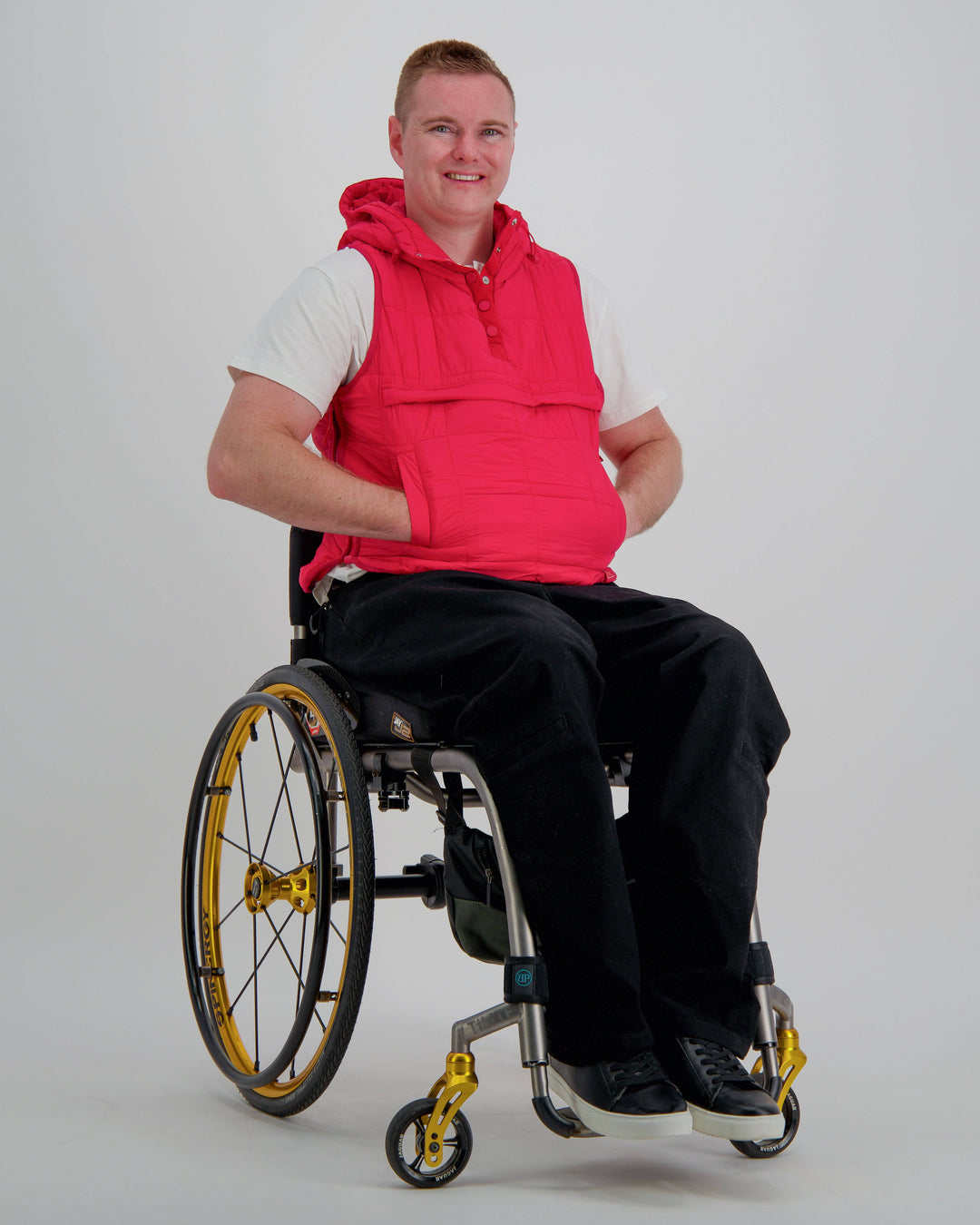 Red adaptive puffer vest by Christina Stephens designed for wheelchair users, showcasing a gender-neutral fit and universal design.