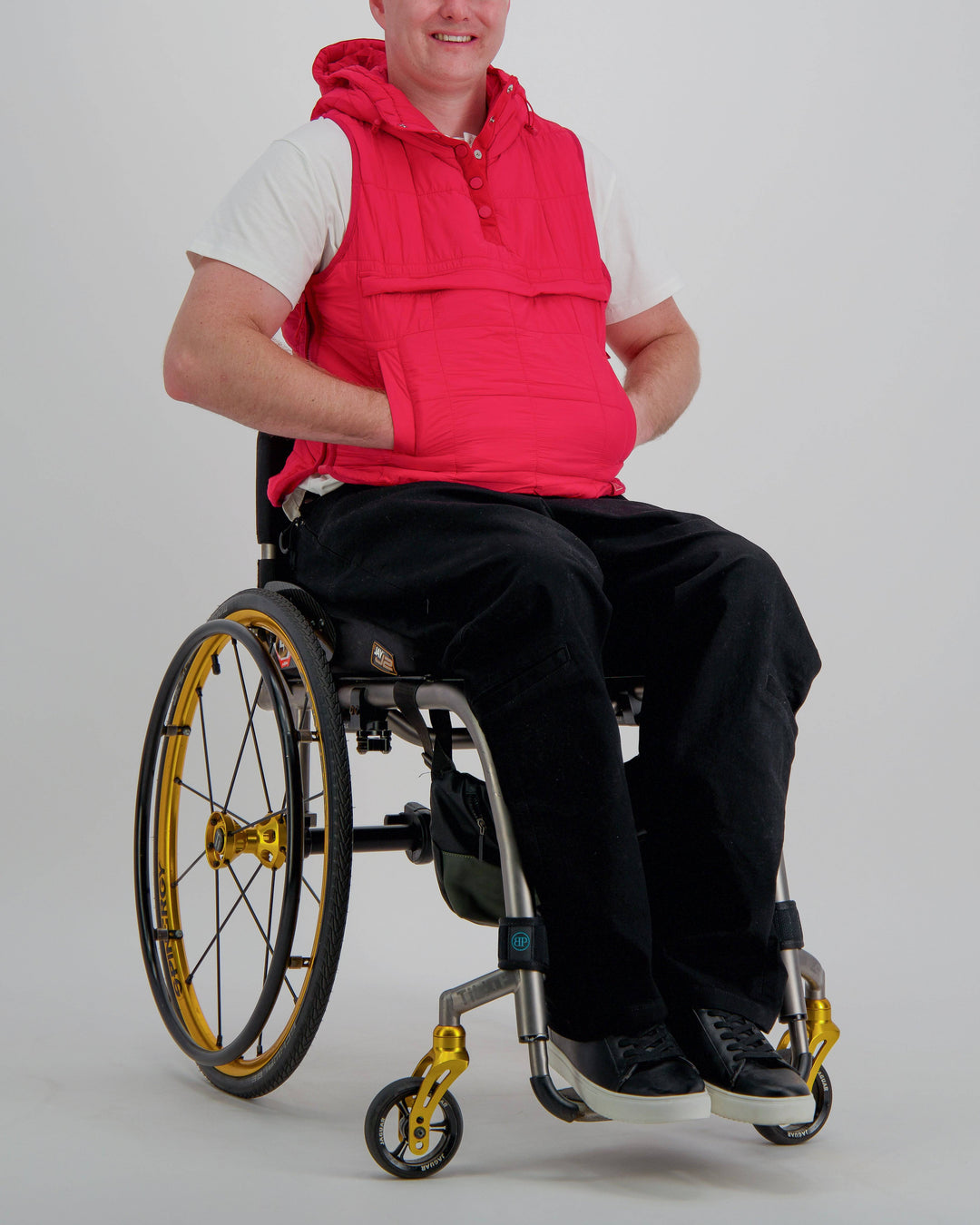 Red adaptive puffer vest by Christina Stephens, designed for wheelchair users, showcasing a gender-neutral style and universal fit.