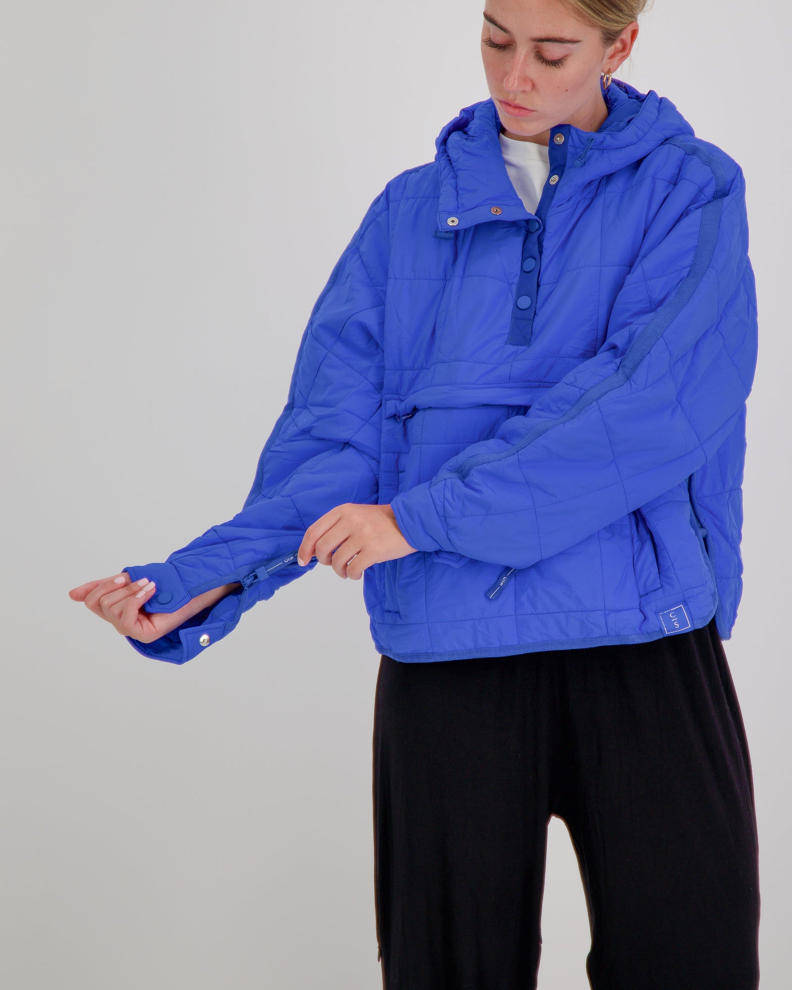 Blue Elly Universal Adaptive Puffer Jacket for wheelchair users by Christina Stephens, showcasing a cozy, functional design.