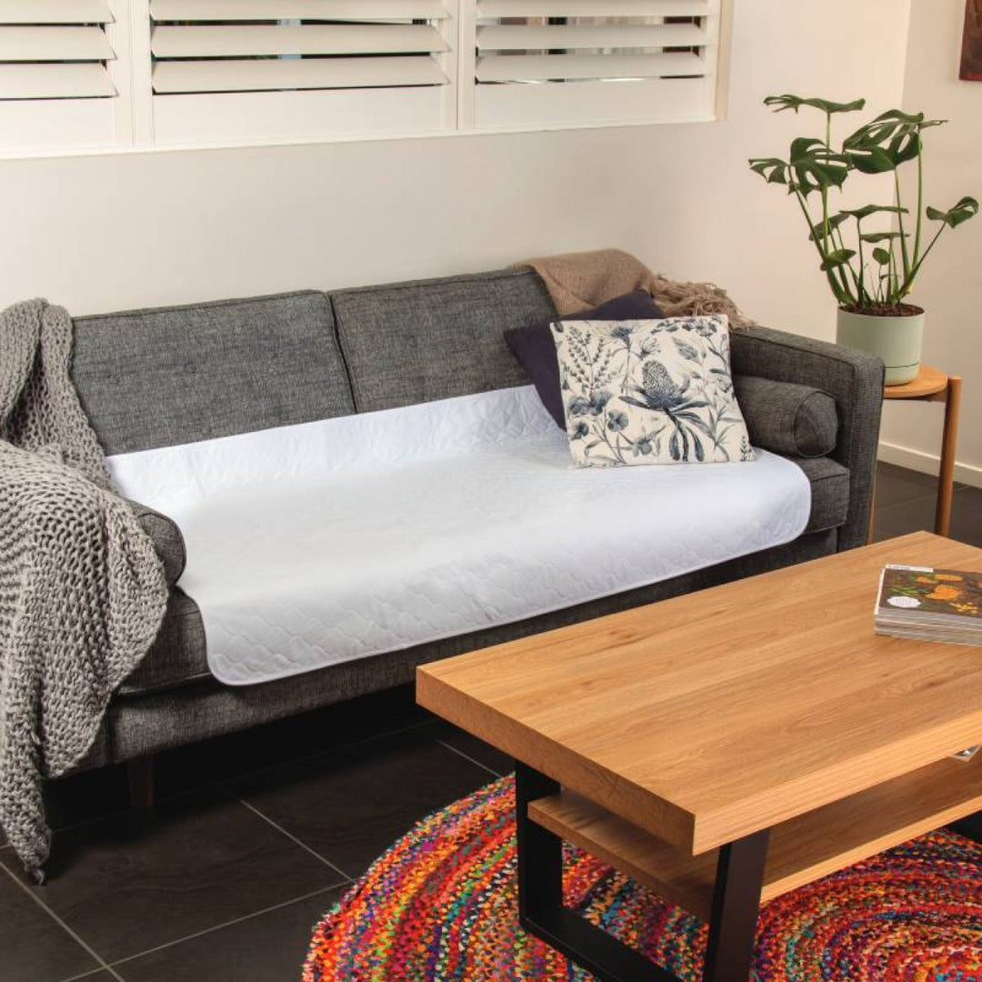 Conni Allrounder Pad in white, showcasing soft fabric and absorbent design for versatile use on couches and furniture.