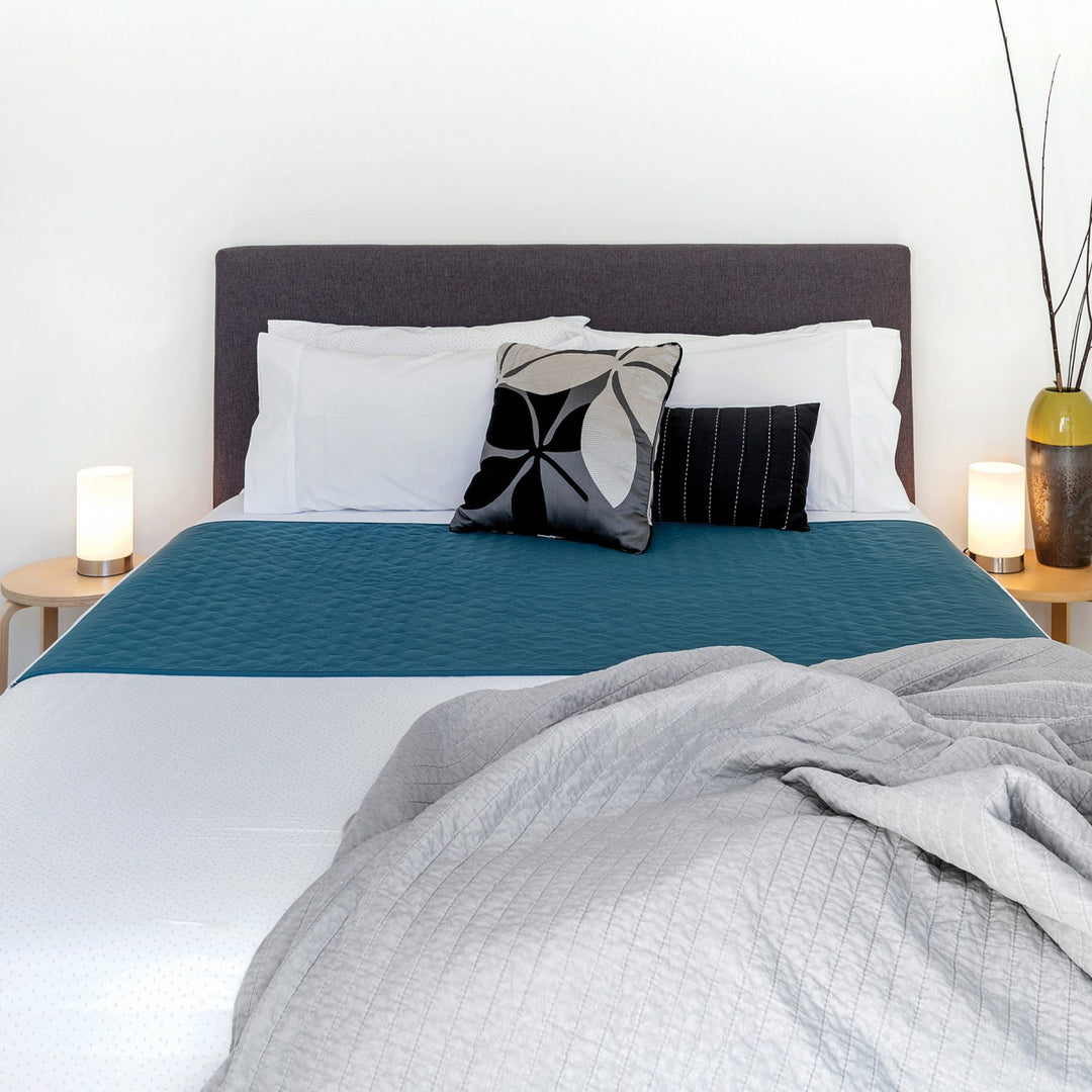Conni X-wide bed pad with tuck-ins, featuring soft fabric and waterproof backing for added protection and comfort.