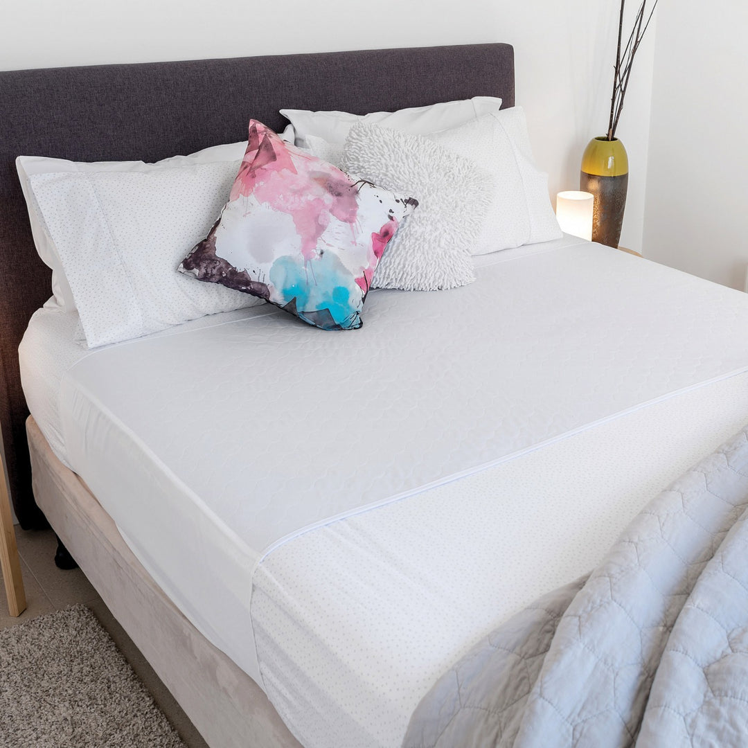 Conni X-wide Bed Pad with Tuck-ins in white, designed for comfort and protection on beds, showcasing soft fabric and tuck-in feature.