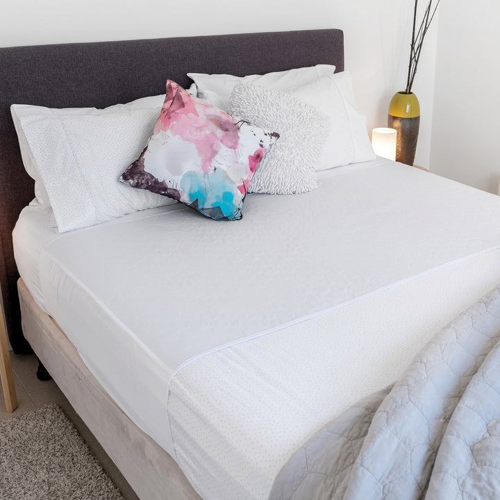 Conni X-wide Bed Pad with Tuck-ins in white, designed for comfort and protection on beds, showcasing soft fabric and tuck-in feature.