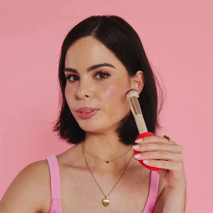 Charlie holding the By Storm Beauty Margie paddle-grip adaptive makeup tool, designed for easier and precise makeup application.
