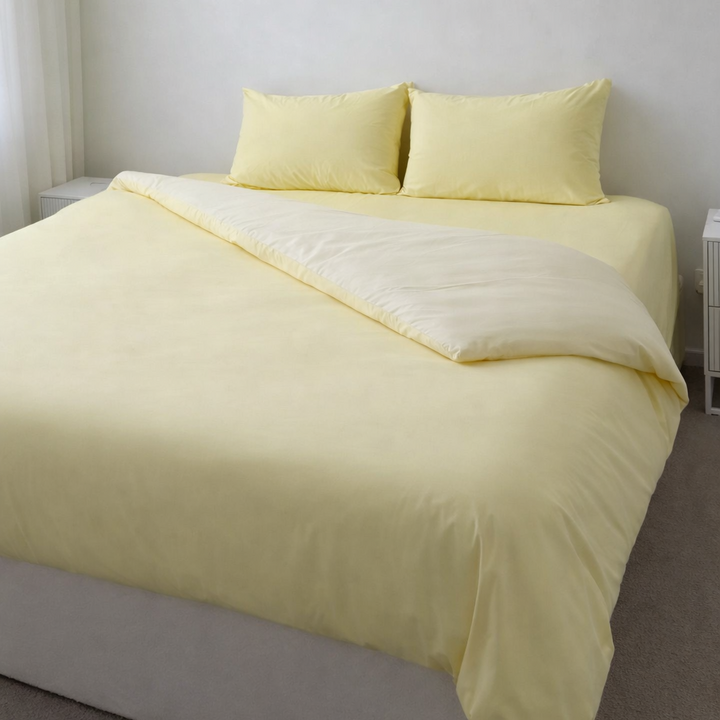 Yellow bedding set on a bed in a minimalistic room.