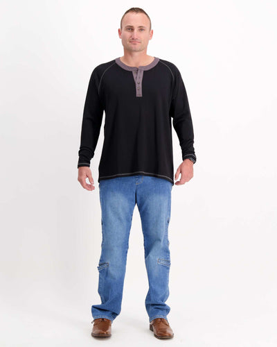 Standing male is wearing a bamboo long sleeve raglan style t-shirt with jeans. Christina Stephens Adaptive Clothing Australia.