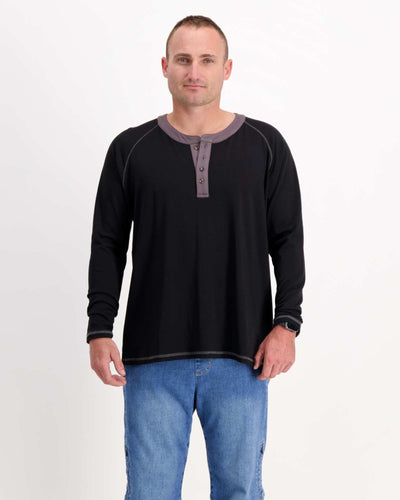 Standing male is wearing a bamboo long sleeve raglan style t-shirt with jeans. Christina Stephens Adaptive Clothing Australia.