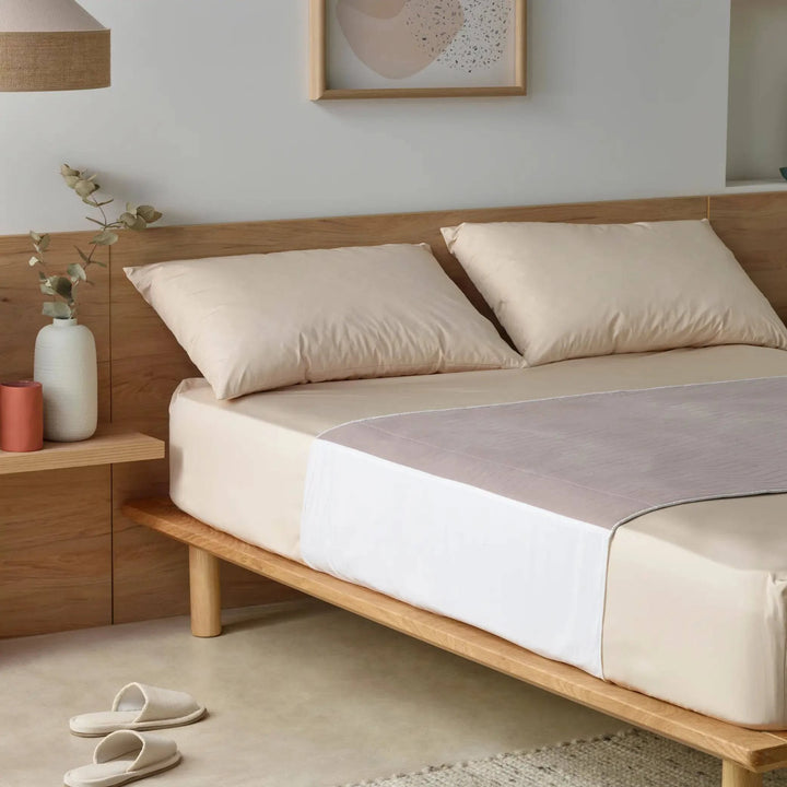 Clay-coloured waterproof bed pad, known as Kylie bed pad placed on a stylish neutral-toned bed. This reusable incontinence bed pad offers high absorbency, leak-proof protection, and a soft quilted design for maximum comfort. Ideal for protecting mattresses from spills, accidents, and night-time incontinence.