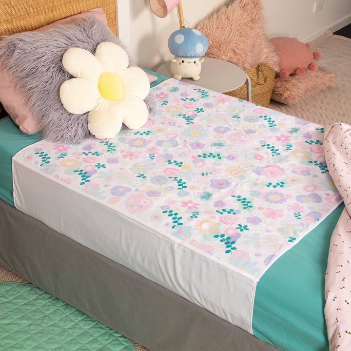 Conni kids bed pad with tuck-ins in a floral print, designed for added mattress protection and comfort for children.