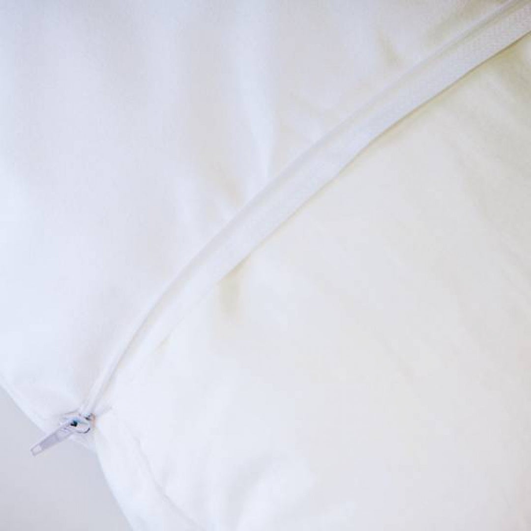Conni Micro-Plush white pillow protector displayed on a soft surface, showcasing its plush texture and design.