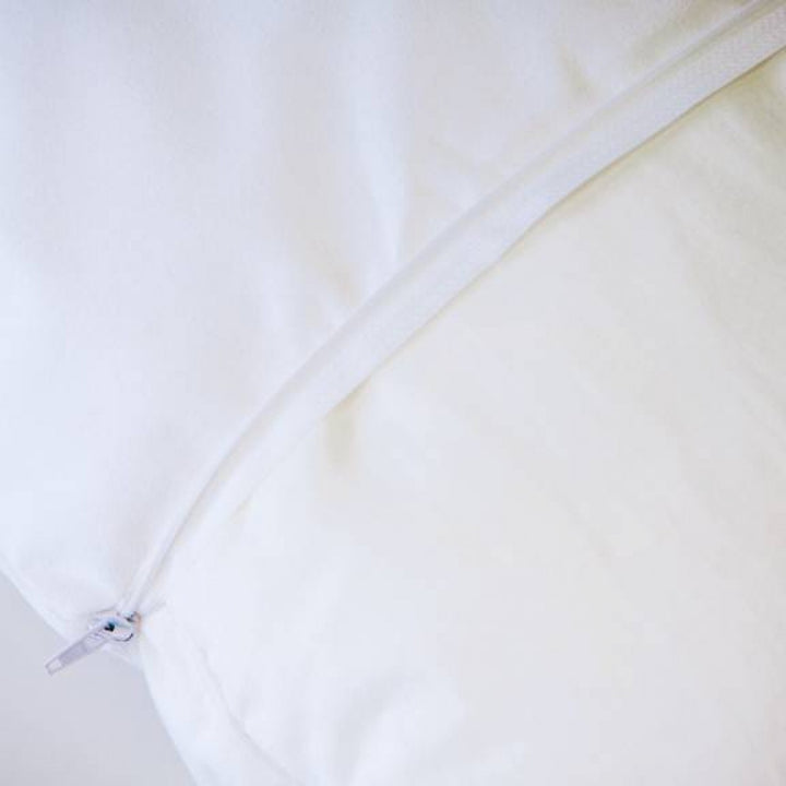 Conni Micro-Plush white pillow protector displayed on a soft surface, showcasing its plush texture and design.