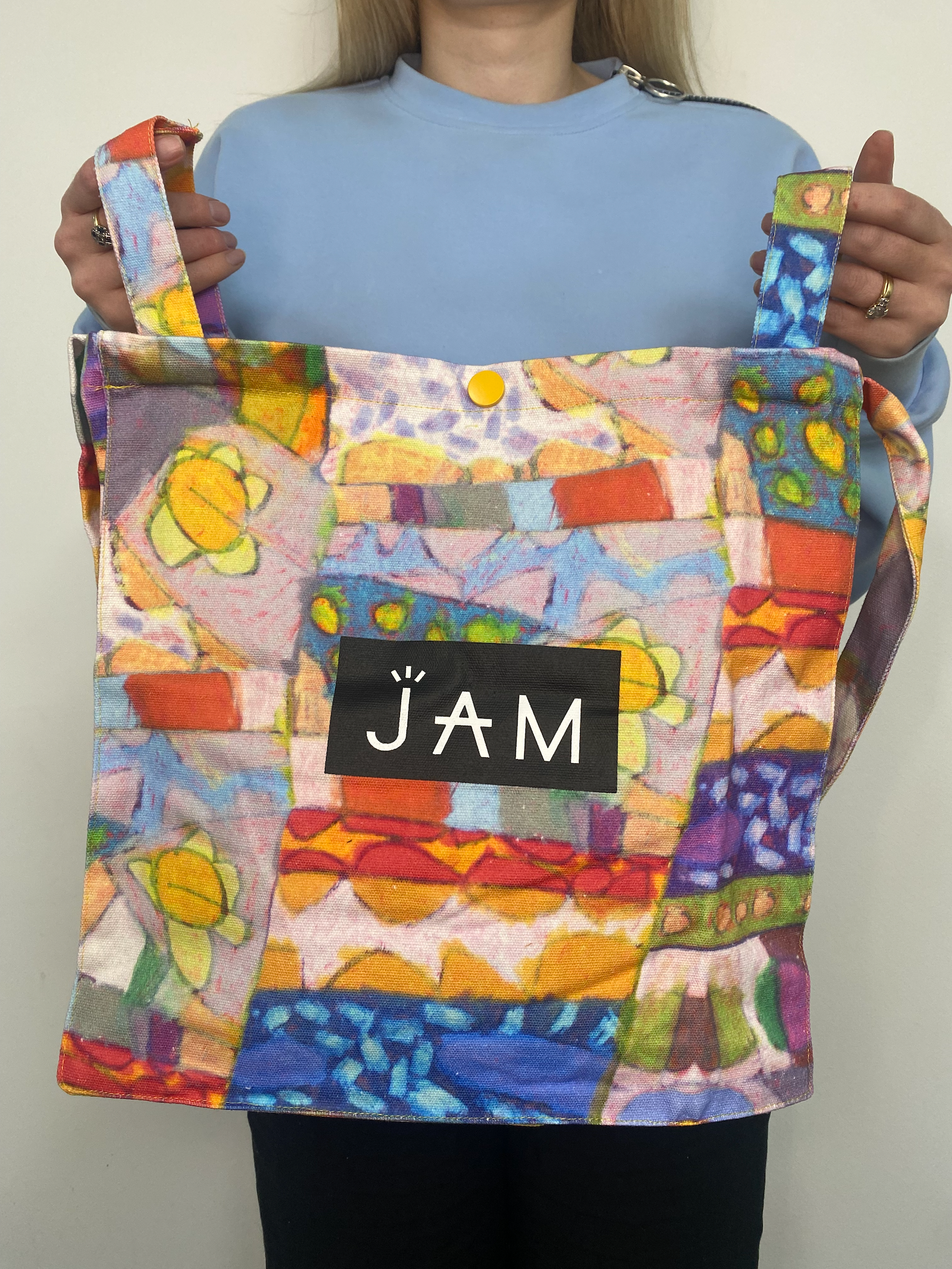 JAM the Label tote bag featuring durable fabric and stylish design, shown in a natural beige color with sturdy handles.