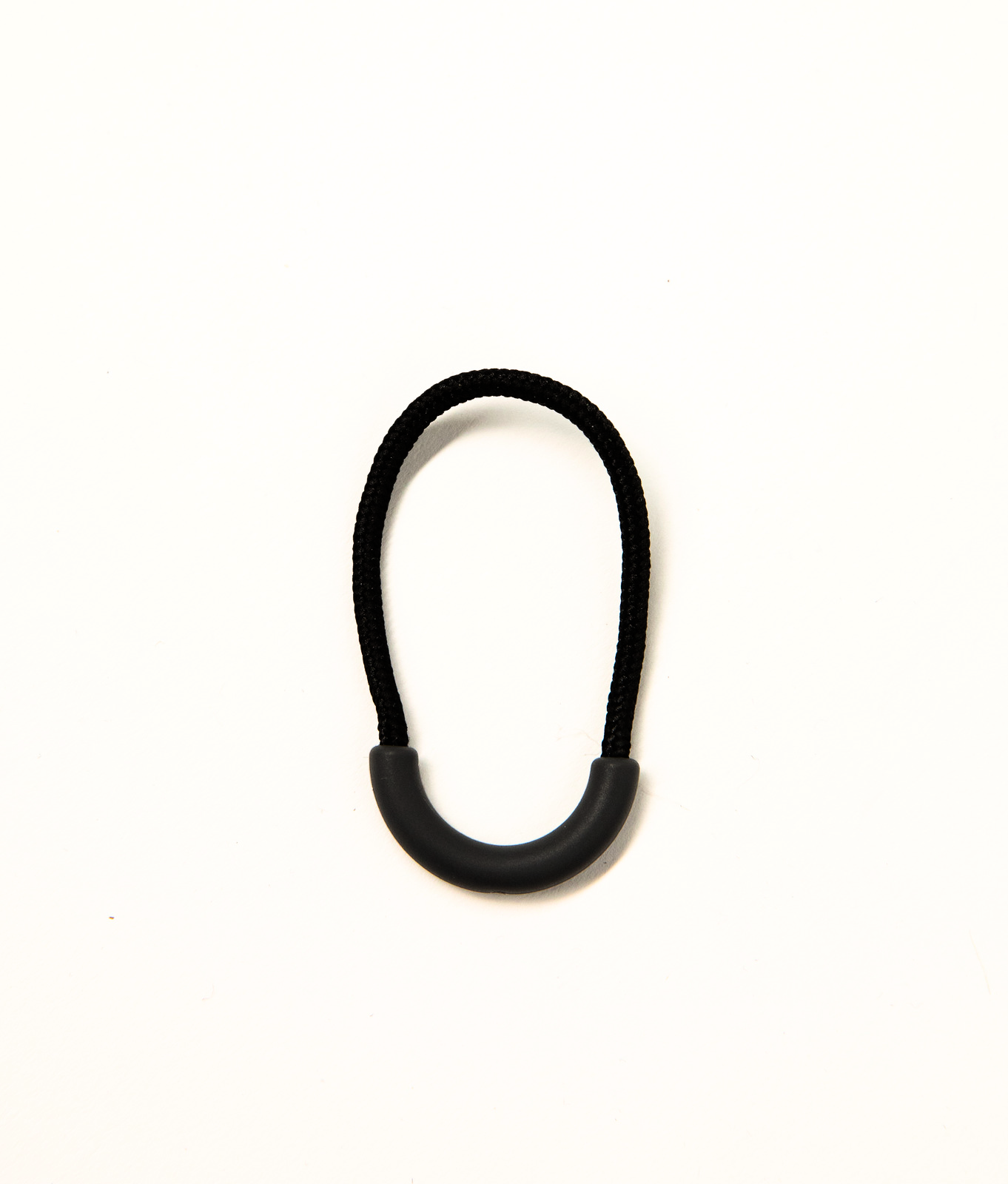 Black clothing zip puller from JAM the Label, featuring a sleek design and durable metal zipper for stylish, functional wear.
