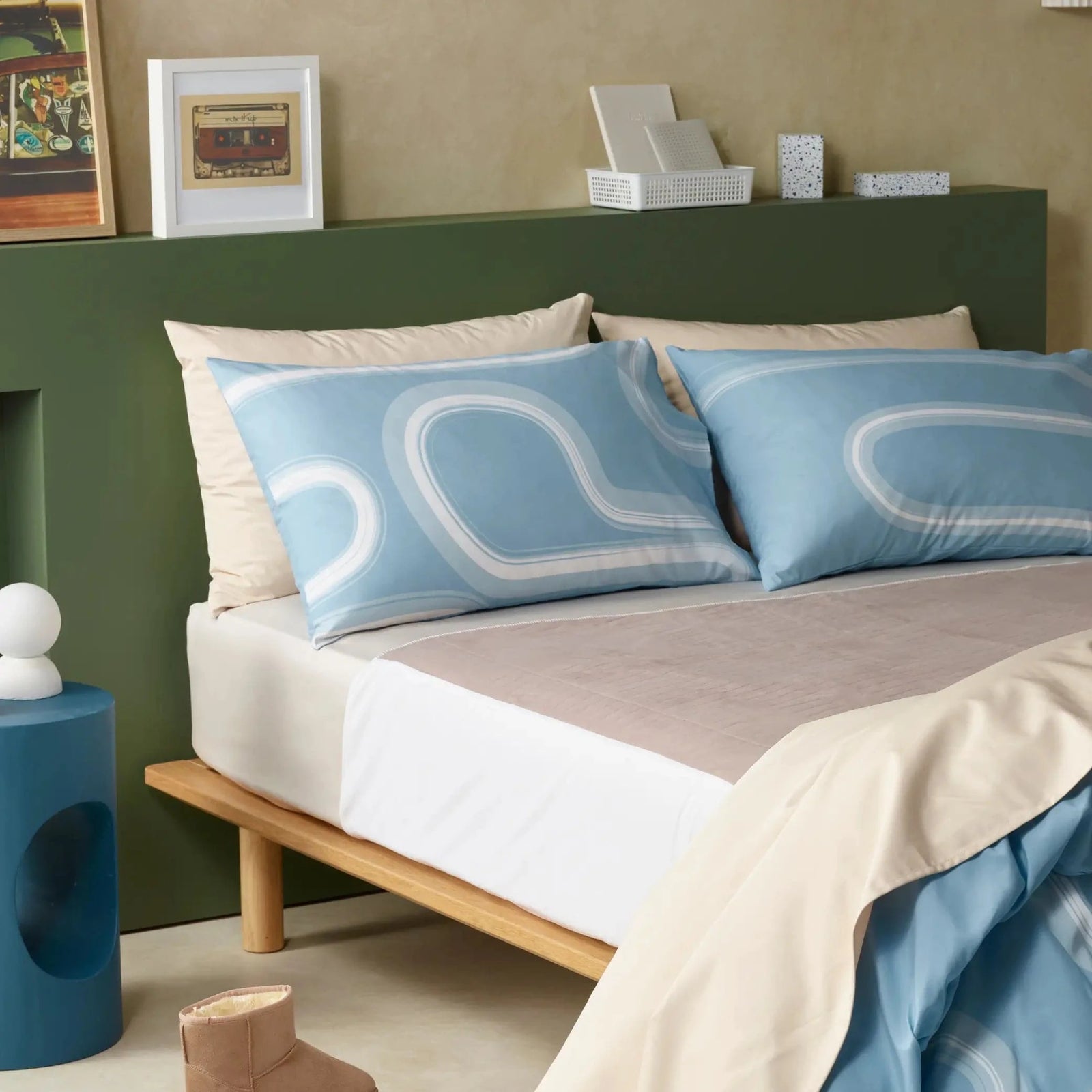 Premium incontinence friendly bedding set featuring waterproof. Designed for comfort and style, this set includes soft beige sheets, a breathable mattress protector, and modern blue pillowcases with a sleek curved pattern. Hypoallergenic, machine washable, discreet. This bed set ensures dry sleep while maintaining a sophisticated bedroom aesthetic.