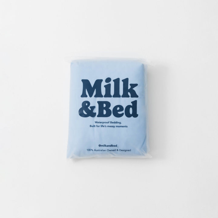 Blue package of Milk &amp; Bed waterproof bedding on a white background