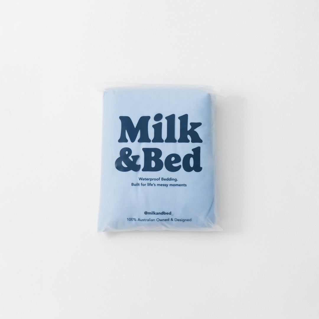 Blue package of Milk &amp; Bed waterproof bedding on a white background