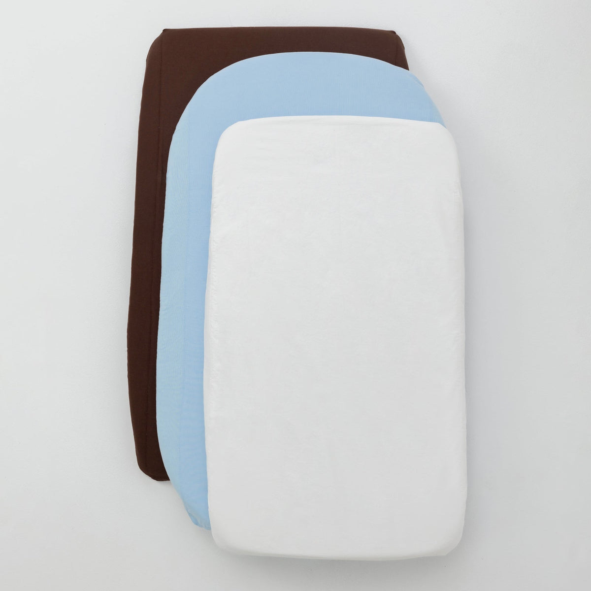 Stack of three fabric swatches in brown, blue, and white on a light gray background