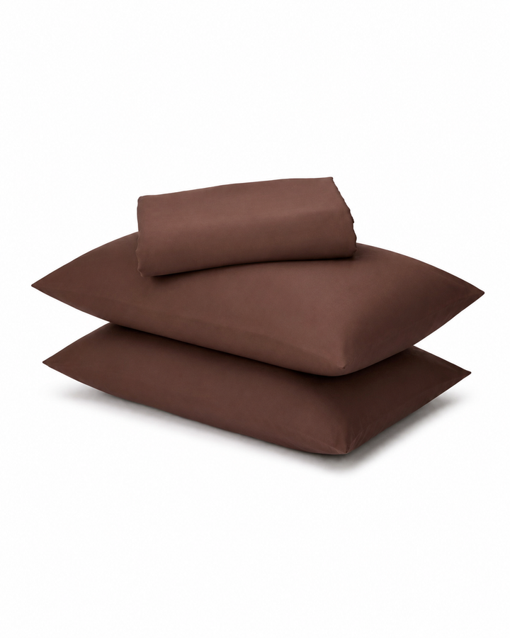 brown pillows and a matching folded sheet or pillowcase stack on a clean white background.