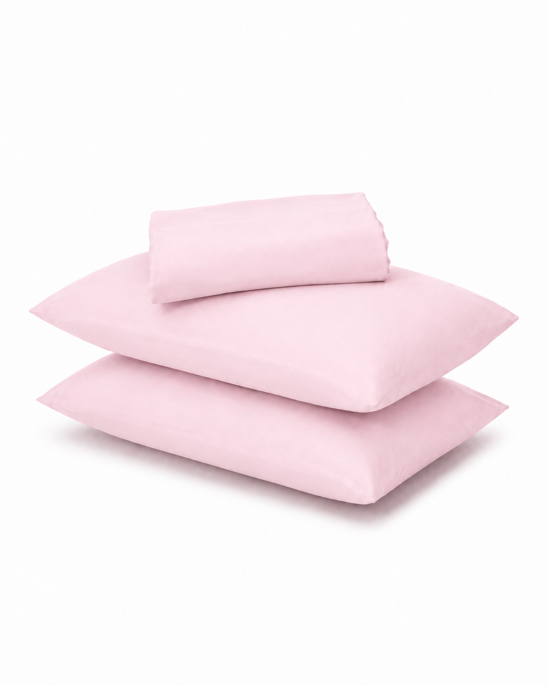 A stack of three light pink pillowcases with a matching folded sheet or pillowcase on top, photographed on a clean white background.