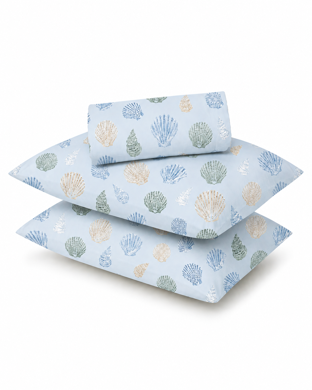 Three light blue pillows and a matching folded sheet set with a seashell pattern in blue, beige, and green, displayed on a clean white background.