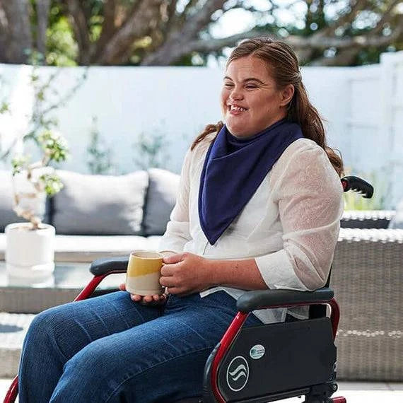 Navy Brolly Bandana waterproof absorbent adaptive clothing on woman in wheelchair, showcasing its fit and fabric texture.