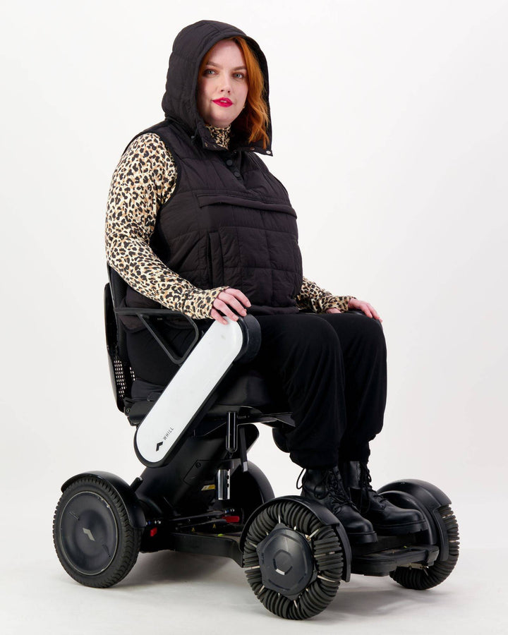 Black adaptive puffer vest by Christina Stephens designed for wheelchair users, featuring a gender-neutral style and universal fit.
