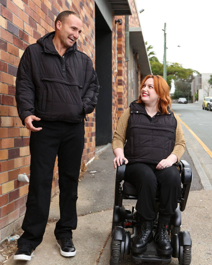 Black adaptive puffer vest by Christina Stephens designed for wheelchair users with a universal fit.