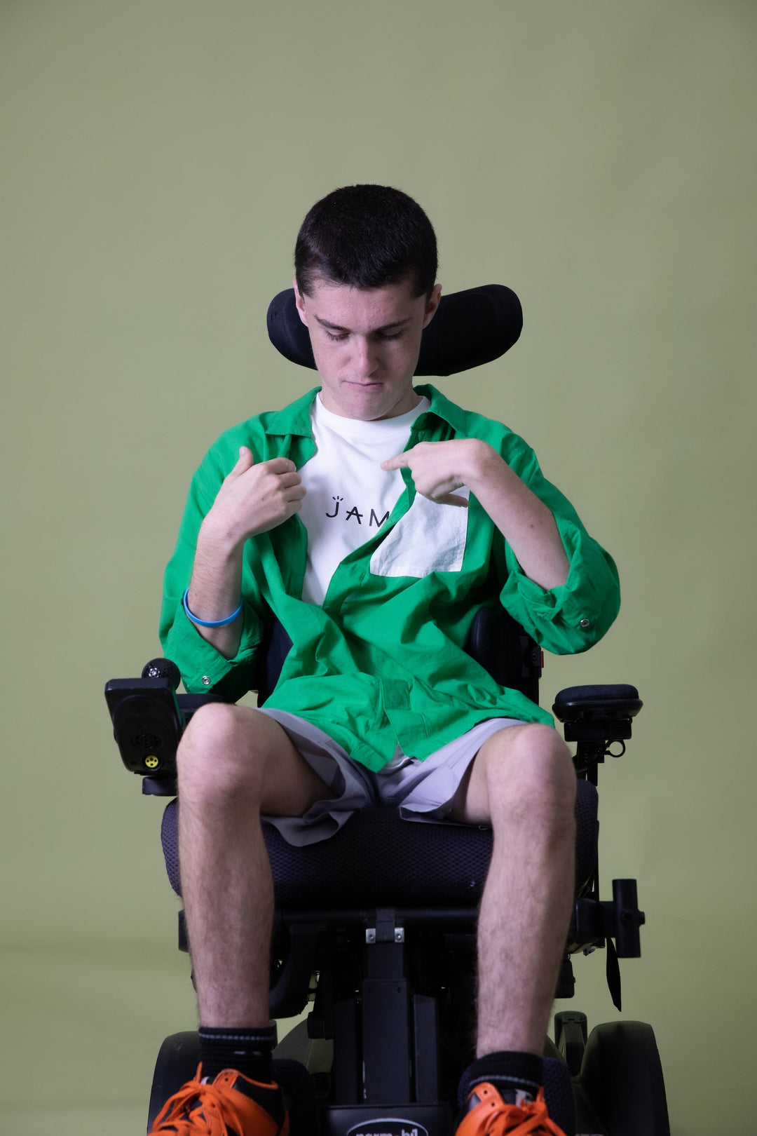 Green long sleeve shirt by JAM the Label, featuring a magnetic front closure, displayed on a seated model.