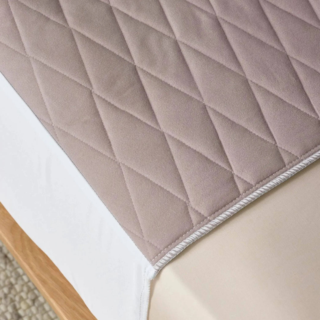 Close-up of a clay-coloured quilted waterproof kylie bed pad, designed for incontinence protection. Made from soft, breathable, and absorbent fabric with a secure fit to keep bedding dry and comfortable.