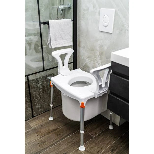 White Performance Health king commode with armrests and hole designed for over toilet use in a mobility aid setting.