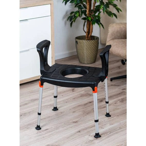 Black King Commode over toilet with armrests in a well-lit bathroom setting by Performance Health.