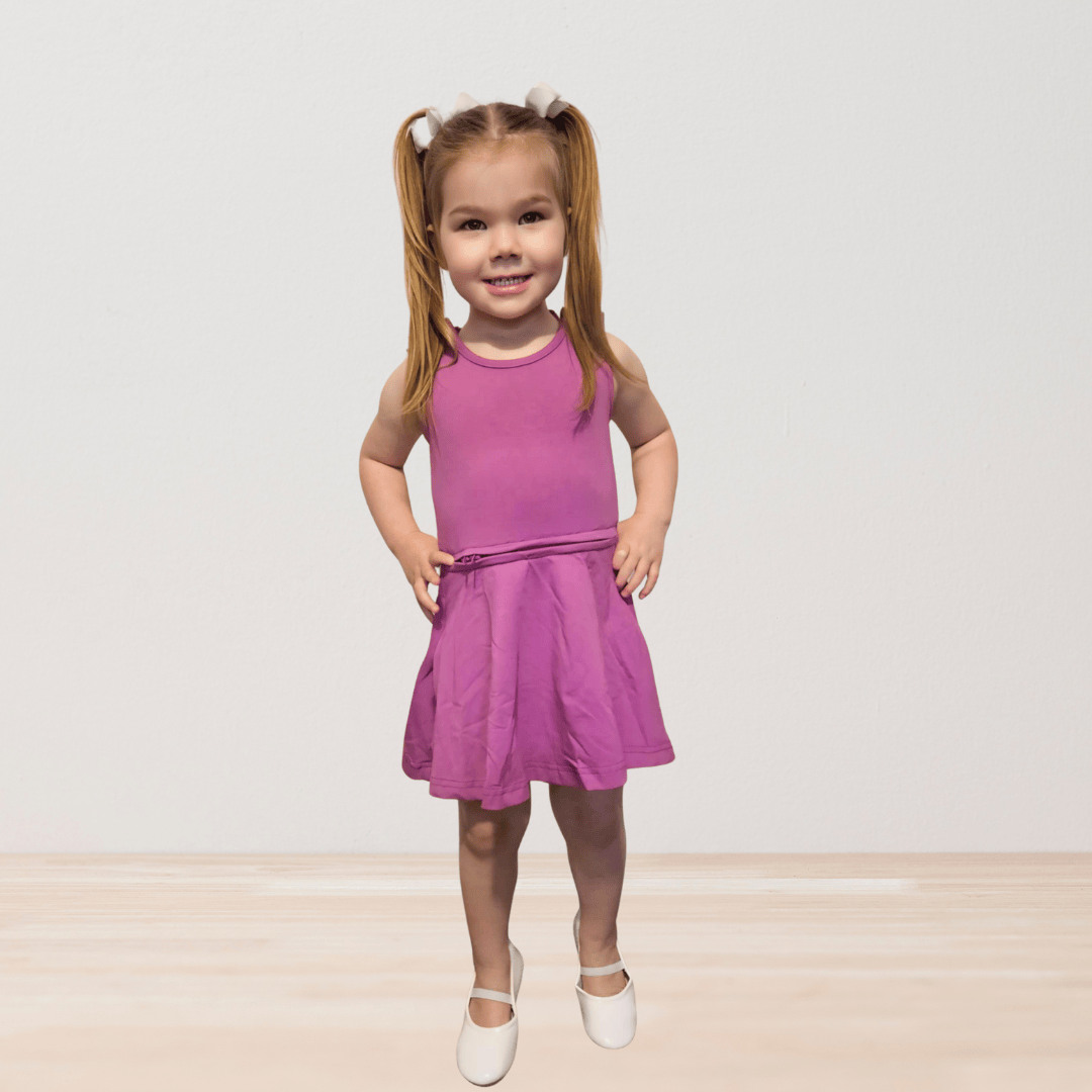 Maeve wearing the RareWear OneEase adaptive dress for kids in purple, showcasing comfortable, stylish clothing by RareWear.