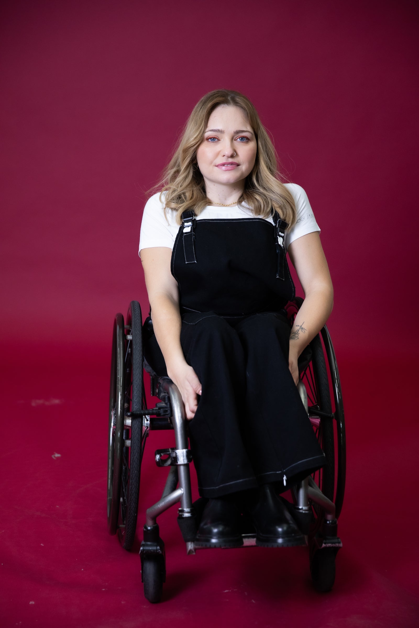 JAM the Label magnetic buckle overalls in a seated position, showcasing the unique buckle design and denim fabric texture.