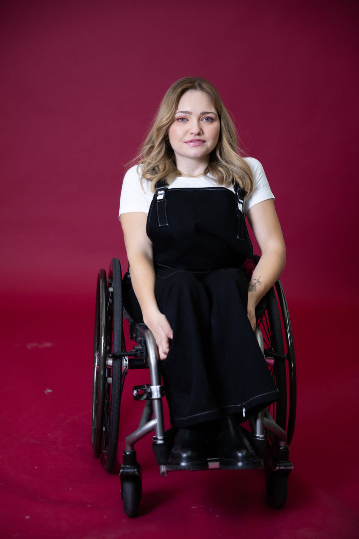 JAM the Label magnetic buckle overalls worn by a person seated, showcasing the stylish clothing design and adjustable straps.