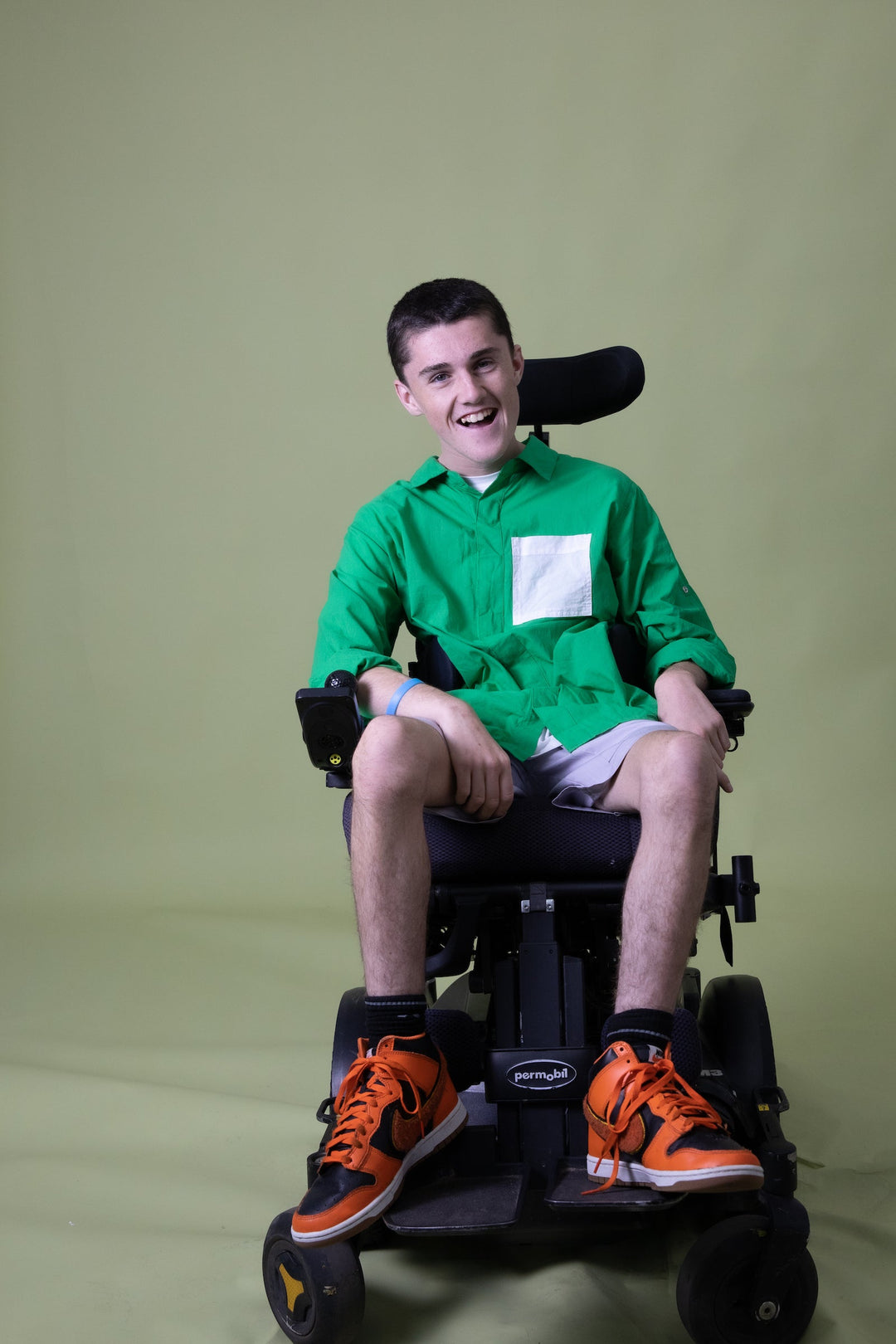 Green long sleeve shirt from JAM the Label, featuring a magnetic closure, shown on a seated model.