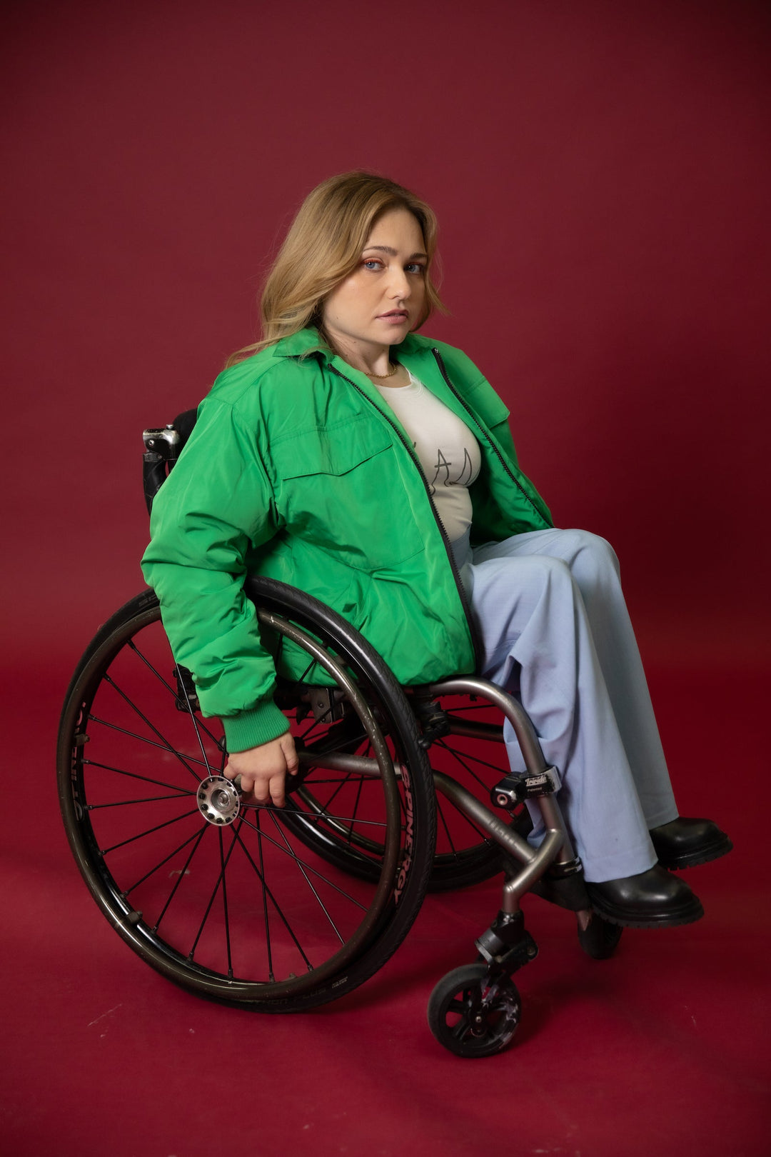 JAM the Label Magnetic Zip Bomber Jacket in a seated pose showcasing its sleek design and magnetic zipper detail.