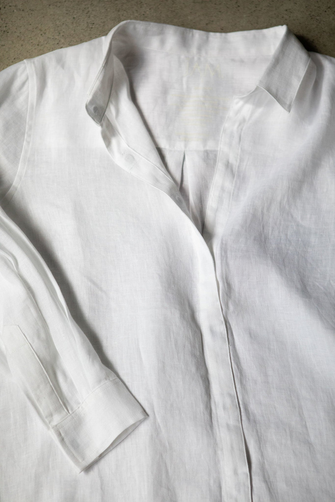 Flat lay of JAM the Label Femme linen shirt, showcasing its relaxed fit and natural fabric texture.