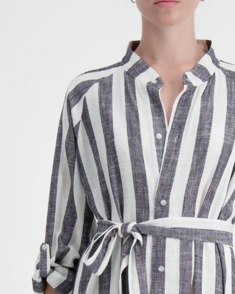 Sapphire Magnetic Shirt Dress in elegant gray and white vertical stripes, featuring a collared neckline, magnetic closures, and a waist-defining belt tie. Close-up view shows the linen fabric texture and relaxed fit of this easy-dressing essential.